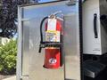 A red fire extinguisher mounted on a metallic surface