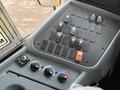 The control panel of a 2013 International 4300 featuring multiple switches knobs and a fuse block