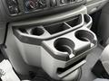 Cup holder section in the center console of a 2013 Ford E-350 with two circular openings and a compartment above for storing items