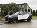 A 2019 Ford Explorer in a two-tone black and white color scheme parked on a wet surface