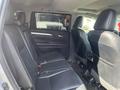 Interior of a 2018 Toyota Highlander showing the second row of seats in black leather with a spacious design and seat belts attached