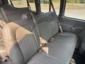The interior of a 2021 Chevrolet Express showing gray leather seats with seatbelts and a spacious seating area