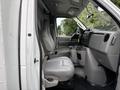 Interior view of a 2017 Ford Econoline showing two gray front seats and a dashboard with controls