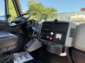 Interior view of a 2013 International 7400 showcasing the dashboard including various controls and gauges with a black driver's seat visible