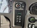 Dashboard controls of a 2015 Freightliner M2 featuring gear selection buttons and various gauges for monitoring vehicle performance