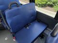 A blue upholstered rear seat in a 2020 Chevrolet Express with seatbelts attached to the side