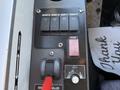 Control panel featuring switches for defrost, driver light, interior light, and hazard lights along with a door controller and user interface elements