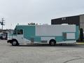 A 2020 Freightliner MT45 service vehicle with a turquoise and white exterior featuring large side panels and windows