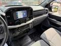 Interior view of a 2021 Ford F-150 showcasing the dashboard with a touch screen and controls on the center console alongside gray seating