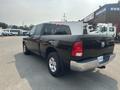 A 2015 RAM 1500 pickup truck in black with a crew cab and short bed is shown from a rear angle featuring the distinctive RAM logo on the tailgate