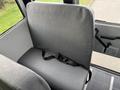 A single gray bus seat with a safety strap attached, designed for passenger seating in a vehicle