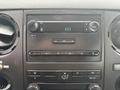 The interior dashboard of a 2014 Ford F-550 with audio controls and climate settings visible
