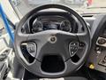 A close-up view of the steering wheel of a 2022 Lion Lion6 vehicle featuring controls for navigation and various functions