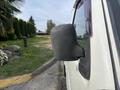 A side mirror of a 2010 Daihatsu Hijet viewed from the side showing its black casing and reflective surface