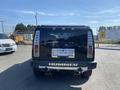A black 2003 Hummer H2 parked with a clear view of the rear featuring dual exhaust pipes and a visible license plate