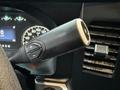 Close-up view of the gear shift lever of a 2023 Ford F-250 featuring buttons for gear selection and a smooth black finish