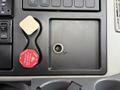 The dashboard of a 2011 International 7500 featuring a red air supply button and a key ignition slot with a button and several dashboard controls above