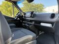 Interior view of a 2020 Mercedes-Benz Sprinter showcasing the dashboard steering wheel and seating area with modern design elements and controls