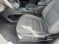 A close-up view of the driver's seat in a 2023 Chevrolet Bolt EV featuring black fabric with a textured pattern and adjustable controls on the side