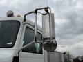 A shiny silver exhaust stack mounted on the right side of a 2016 Peterbilt 348 truck with a chrome mirror attached