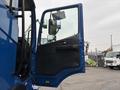 A blue 2017 Autocar Xpert truck with the driver's door open revealing the interior and side mirror