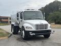 A 2006 Freightliner M2 106 truck with a white body and chrome accents is parked, featuring front-facing headlights and a clean design