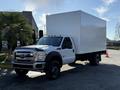 A 2010 Ford F-450 box truck in white with a large cargo area and orange lights on the cab
