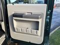 The interior door panel of a 2008 Ford F-550 featuring a large storage compartment and a black handle