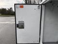A white door of a utility body on a 2006 Ford F-450 showing a metal latch and some surface wear