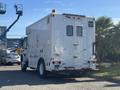 A white 2008 International 4400 truck with a boxy, utility-style design featuring multiple doors and a high visibility safety light on top