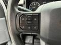 Steering wheel controls of a 2021 Ford F-150 displaying buttons for cruise control audio settings and other functions