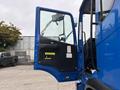 A blue 2017 Autocar Xpert truck with its driver's door open, revealing the interior controls and seat