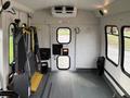 Interior of a 2009 Ford Econoline featuring a wheelchair lift on the left side and two large windows on the right side with a door at the rear