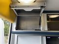 Interior storage compartment with a hinged lid inside a 2020 Mercedes-Benz Sprinter 2500 van