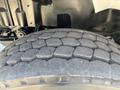 Close-up of a tire from a 2013 International 7500 showing a heavily worn tread pattern with distinct grooves and a rugged surface