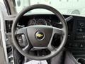 Steering wheel of a 2021 Chevrolet Express featuring the Chevrolet emblem and dashboard with various gauges and controls