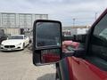 A red 2013 Ford F-550 with a side mirror visible in the foreground