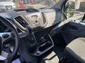 Interior view of a 2019 Ford Transit 350 showing the dashboard gear shift controls and seating area