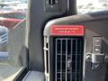 A dashboard view of a 2013 Chevrolet Express showing a red label indicating maximum height of 2.62 meters and a vent next to it with control buttons