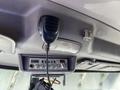 A black ICOM CB radio microphone is mounted on the ceiling of a 2009 Peterbilt Highway interior with a control panel featuring multiple knobs and a digital display