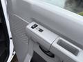 Close-up of the interior door panel of a 2013 Ford E-350 featuring window controls and a handle