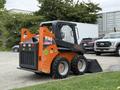 A 2017 Gehl R105 skid steer with an orange and black exterior featuring chunky tires and a bucket attachment in front