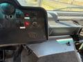 Cockpit of a 2012 Ford Econoline featuring various controls switches and gauges with a prominent steering wheel and dashboard layout