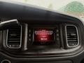 A 2017 Dodge Charger's dashboard featuring a touchscreen display with a message about driving safety and Uconnect features