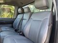 Interior of a 2011 Ford F-550 showing two front seats with gray upholstery and seatbelts