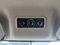 Controls for air conditioning and heating displayed on a panel with three circular dials in a vehicle interior
