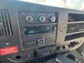 The interior dashboard of a 2020 Chevrolet Express featuring climate control knobs a radio display and several input buttons