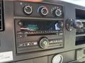 The dashboard of a 2017 Chevrolet Express featuring a radio display with FM station information and controls for volume and tuning