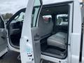 Interior of a 2005 Ford F-350 SD showing an empty back seat area with gray upholstery and a partially open door