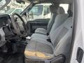 Interior view of a 2014 Ford F-250 SD showing gray cloth seats with a worn patch on the driver's side and a simple dashboard design